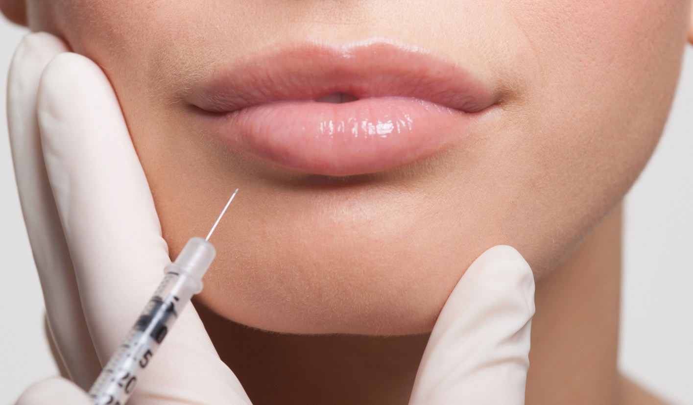 Close up of woman receiving botox injection in lips